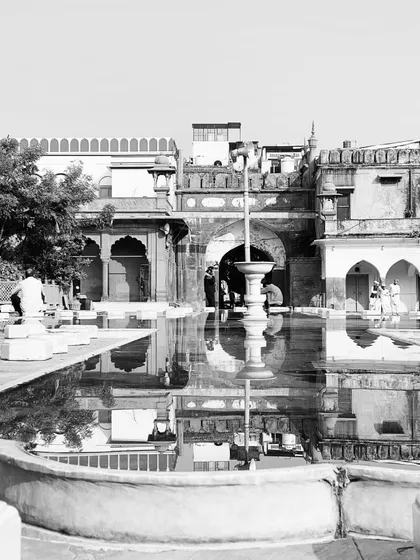 The stunning reflection of a historic building in a fountain's water. We encourage you to see the beauty in the details and find unique perspectives on our architectural walks.