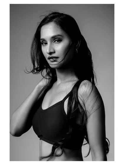 A bold and confident black and white shot for an activewear brand. The strong contrast and clean lines emphasize the model's form and the product's design.