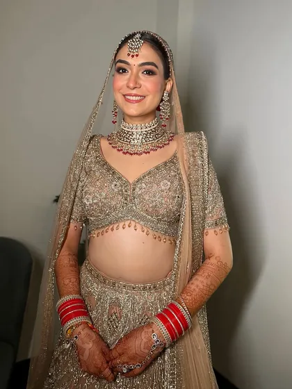My new-age bride serving major glam goals in her stunning gold ensemble. The makeup is all about a flawless glow that complements the intricate outfit.