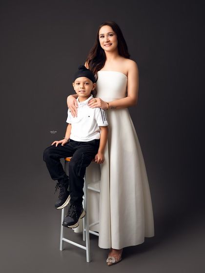 A beautiful portrait of a mother and her son. Her elegant white dress and his smart outfit create a polished and loving image.