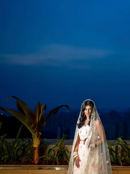 A stunning bridal portrait against the deep blue twilight sky, creating a sense of peace and beauty.