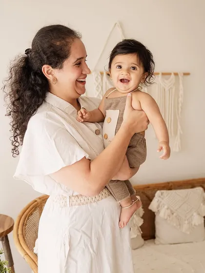 A mother shares a laugh with her baby. This candid shot is full of life and perfectly captures the joy of motherhood.