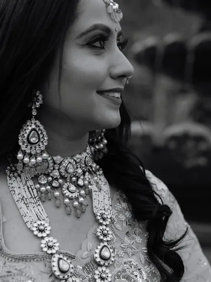 A classic black and white profile of the bride, highlighting her intricate jewelry and radiant smile. This timeless style emphasizes her beauty and elegance.