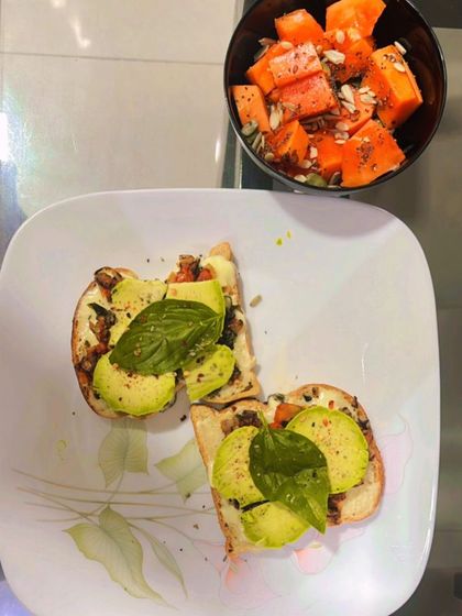 A client's breakfast of avocado toast with a side of fresh papaya and seeds. A perfect combination of healthy fats, fiber, and vitamins.
