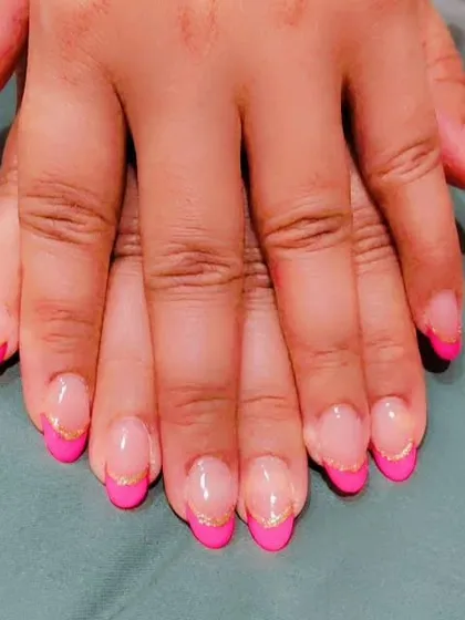 A modern take on the French manicure using a vibrant hot pink for the tips on almond-shaped nails. I added a fine gold glitter line to separate the pink from the natural base, giving it a sharp and stylish finish.