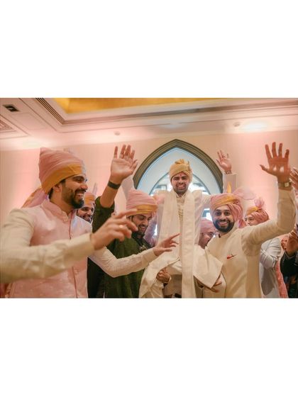 The groom's triumphant entrance, lifted up by his friends. A classic Baraat moment full of energy, friendship, and excitement.