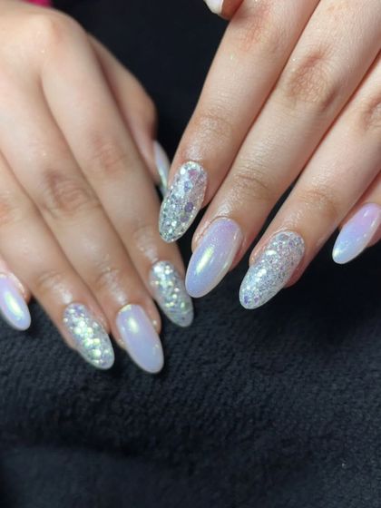 A mix of pearly white and silver glitter nails for a simple yet glamorous look.
