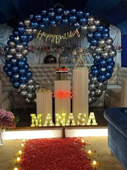 A duplicate of image 120, showing a blue and silver balloon arch in a lounge setting.