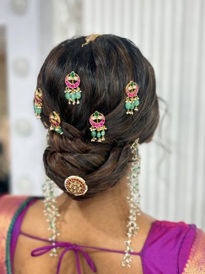 A beautiful textured bun decorated with multiple pieces of traditional temple jewellery, creating a very royal and intricate look.