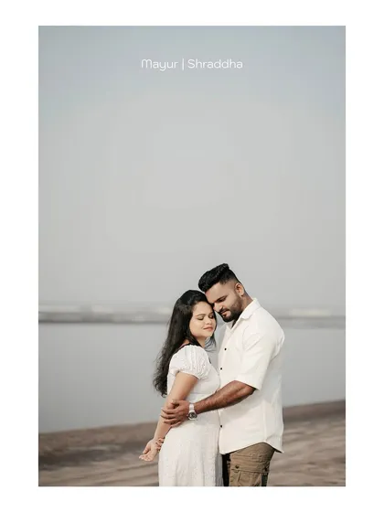 A wide-angle shot of the couple by the sea, creating a sense of peace and solitude. The text overlay adds a personalized touch.