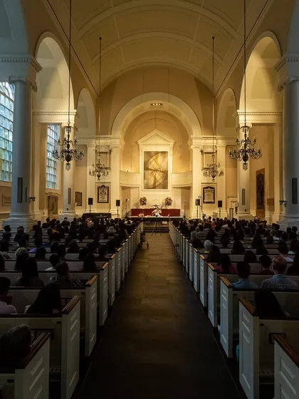 A wide shot of the stage and audience at All Souls NYC. The combination of the grand organ, the historic architecture, and the sitar created a truly unique and powerful ambiance for healing.