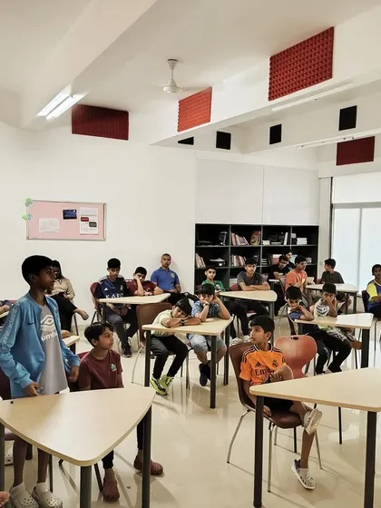 Young players listen attentively during a classroom session with a coach. This shows that learning at our camps happens both on the pitch and through tactical and theoretical instruction.