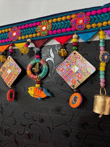 This is 'The Summer Song' toran, a custom piece I finished in just one day. It features my art on diamond shapes, colorful fish, and thread-wrapped rings.