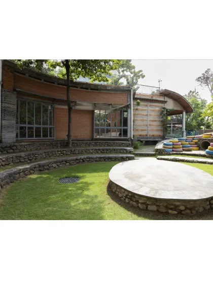 The campus is designed as a series of interconnected spaces. The view from the main building looks out onto the central amphitheater, reinforcing the link between indoor learning and outdoor community activities.