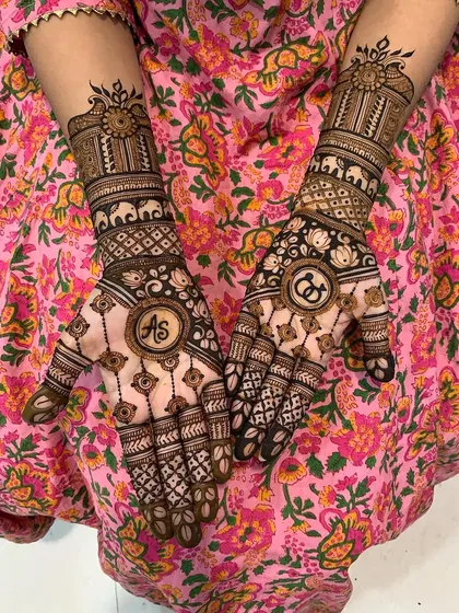A personalized engagement mehndi design incorporating the couple's initials 'AS' and 'CG' into the central mandalas. This is a wonderful way to make your mehndi unique to your love story.