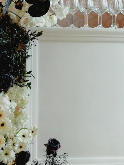 A detail shot of the black and white theme, with a beautiful arrangement of black and white flowers next to a champagne tower.