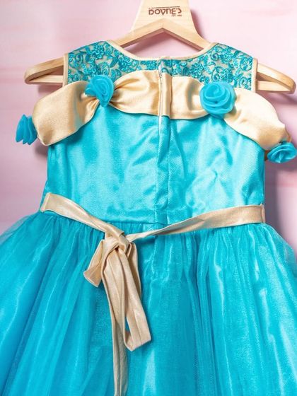 This bright turquoise gown features gold accents and delicate blue roses on the shoulders. It's a glamorous and eye-catching design for a very special occasion.