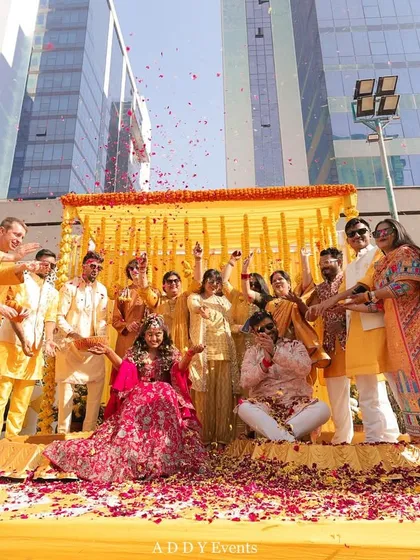 A moment of pure, unadulterated joy. The bride and groom are showered with flower petals by their loved ones during a fun-filled Haldi ceremony.