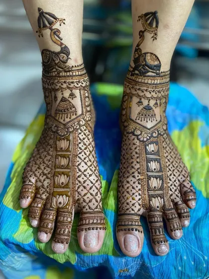 This unique design features a peacock on an elephant at the ankle, with lotus and geometric patterns covering the rest of the foot.