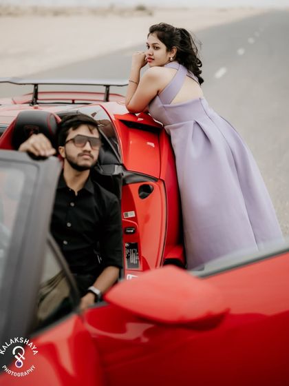 A different angle of the couple and the car, highlighting the sleek lines of the vehicle and the couple's connection.