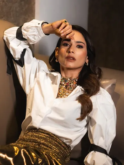 A close-up of Aneri Vajani, her confident pose highlighting the intricate craftsmanship of the multi-colored heritage necklace.