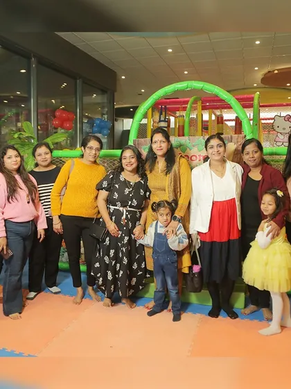 Moms and kids gather for a group photo in the play area during the LEGO-themed party.