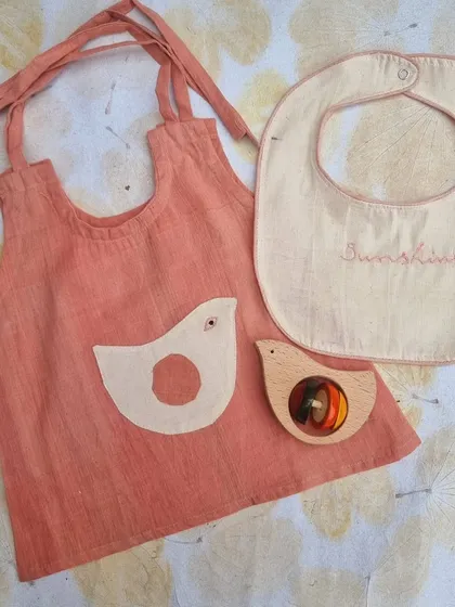 We collaborated with Sankalpa Art Village to create this thoughtful gift set for newborns. It features a soothing handloom Kora cotton top, naturally dyed with plants like manjistha, and a matching bib. Paired with one of our classic Channapatna wooden rattles, it’s a perfect blend of two crafts rooted in sustainable, women-led artisanship.