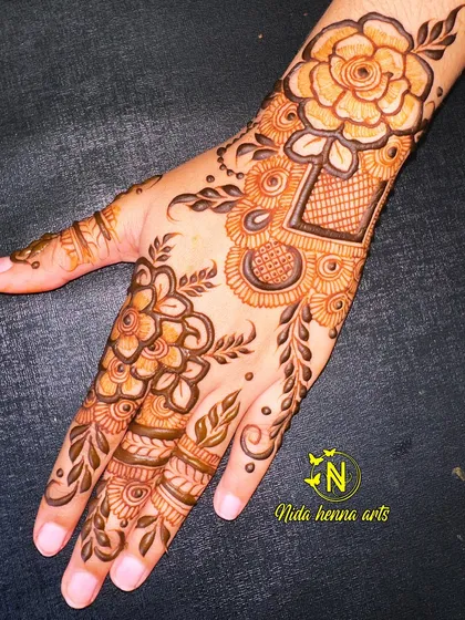 An elegant floral design perfect for Eid celebrations. This style combines bold flowers with delicate leaves and net patterns, creating a beautiful look for the back of the hand.