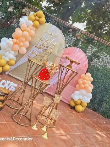 An angled view of the pastel outdoor birthday decoration, showing the arrangement of the golden props and "LOVE" sign.