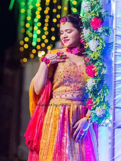 Another shot from the Haldi ceremony, showing how the makeup and hairstyle complement the colorful floral decor and outfit.