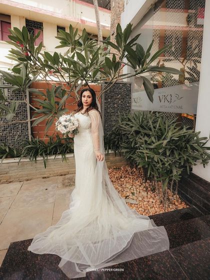 An elegant full-length portrait of the bride, her long, beautiful veil and gown creating a stunning silhouette.