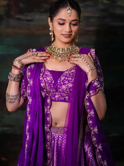 A close-up shot focusing on the bride's jewelry and the detailed embroidery on the blouse. This type of shot is essential for showcasing the craftsmanship of bridal couture.