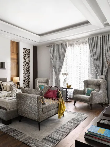 Another view of the grey-toned bedroom, highlighting the comfortable seating area with wingback chairs, perfect for a quiet morning coffee.