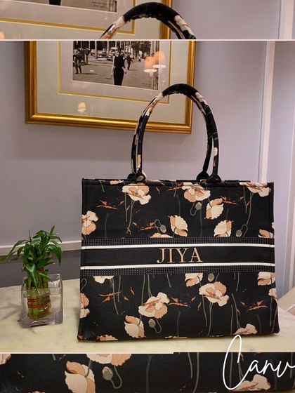 A beautiful black floral canvas tote bag, personalised with the name 'Jiya'. It's a chic and versatile accessory.