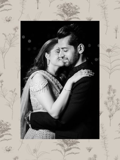 A romantic black and white portrait of a couple embracing, framed by a delicate floral border.