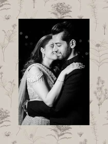 A romantic black and white portrait of a couple embracing, framed by a delicate floral border.