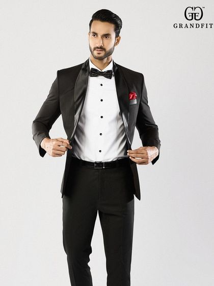 This image displays the clean interior and structure of our tuxedo jacket. The crisp white formal shirt with black studs provides a sharp, classic contrast.