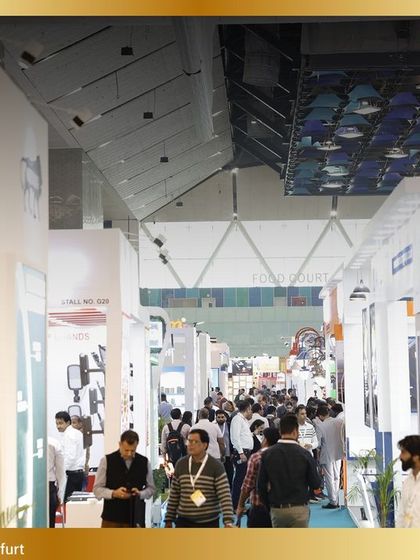 A wide-angle view of the bustling show floor, with attendees navigating through aisles of exhibitor booths.