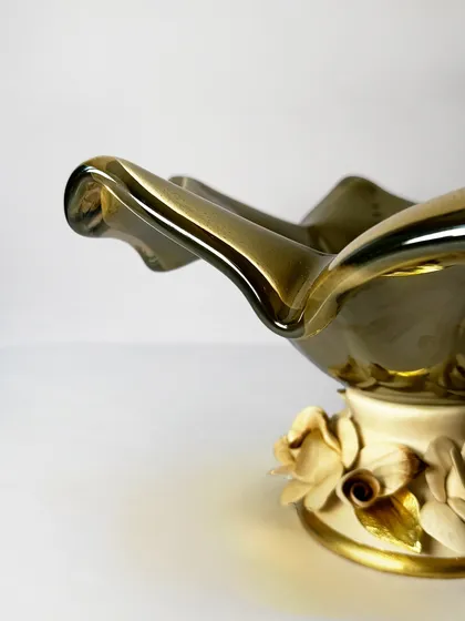 A detail shot of the ruffled edge of the smoky Murano glass bowl. The organic shape and translucent quality of the glass make it a stunning statement piece for any interior.