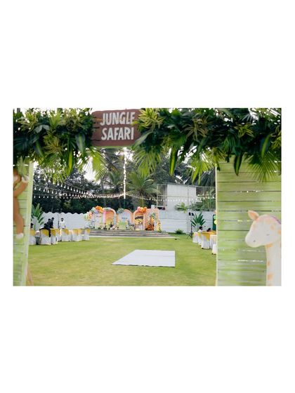 Guests are welcomed to the jungle through this grand entrance. The path is lined with lush greenery and themed signs, leading to the main party area for an exciting safari adventure.