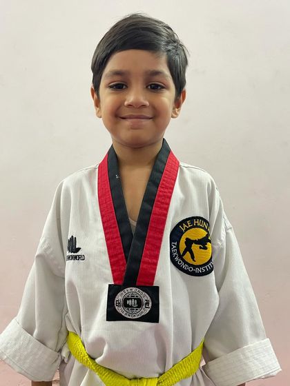 This young boy is a champion. His medal is a symbol of his hard work and the skills he has developed at our academy.