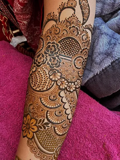 A close-up of the arm, showing the beautiful details of the peacock and floral patterns.