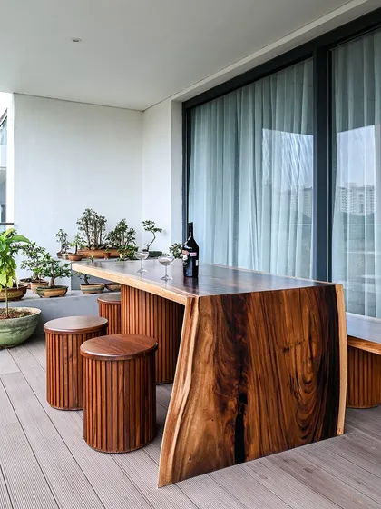 Craftsmanship is at the heart of our work. This monolithic live-edge deck table, paired with custom stools and a collection of bonsai, creates a stunning and unique outdoor space for relaxing and entertaining.