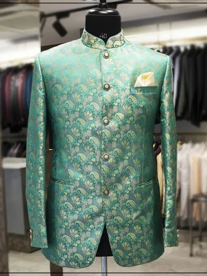 A sea-green brocade bandhgala with a gold paisley pattern. The vibrant color and classic Indian motif make this a perfect choice for festive occasions.