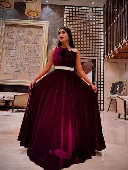 Make a show-stopping entrance at your reception or cocktail party with this luxurious magenta velvet gown. The structured bodice and flowing skirt create a dramatic silhouette, ensuring all eyes are on you. It's a perfect blend of modern design and opulent fabric.
