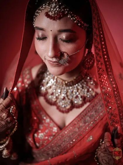 A serene close-up of the bride in her red wedding attire, capturing her calm and beautiful expression.