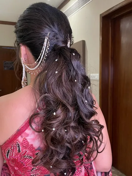 A messy ponytail with scattered pearls, a popular and trendy choice for modern brides and bridesmaids.
