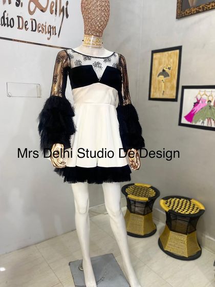 A unique western country-style outfit. This custom dress features black fur-trimmed sleeves, a velvet bodice, and a white skirt for a look that's both edgy and chic.