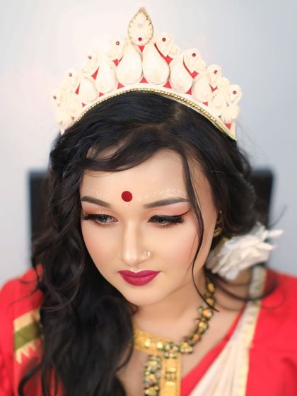A classic bridal portrait focusing on the intricate details of the 'mukut' and the soft, elegant makeup of the Bengali bride.