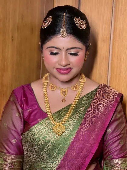 Eyes closed, showcasing the soft and shimmering eyeshadow that adds a touch of glam to this traditional look.